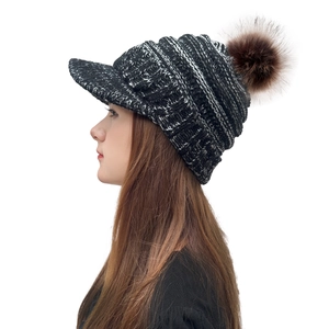 Women's knit beanie with visor and brown faux fur pom pom in black white mixed color