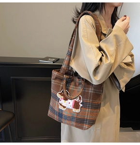 Detail view of the brown plaid wool tote bag with a cute cartoon puppy embroidery patch