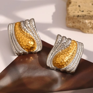 Macro detail of two-tone hammer textured rectangular earrings in gold and silver finish