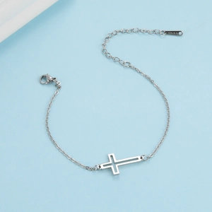 Elegant silver stainless steel bracelet featuring a hollow cross pendant on light blue background