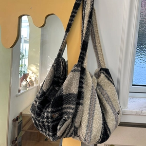 Close-up of textured faux shearling fabric and pattern on the large crossbody bag