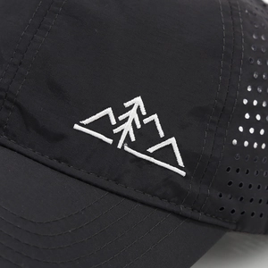 Detail of white mountain embroidery and laser-cut vents on black quick-dry mesh cap