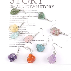Detail of handmade silver wire wrapped natural raw crystal quartz earrings set