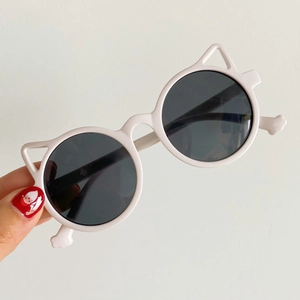 Detailed view of white children's sunglasses with cute cat ear frame design