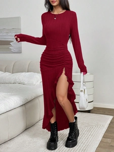 Close-up of wine red knitted dress featuring side ruching and ruffled hem detail