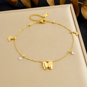 Macro view of gold plated butterfly charm bracelet with sparkling zircon accents