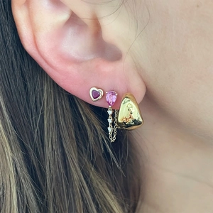 Close-up of a model wearing S925 silver earrings with pink teardrop gems and gold heart studs