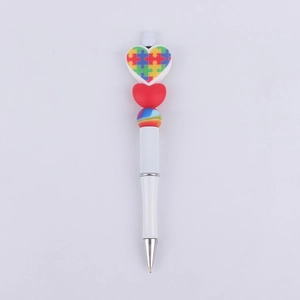 Detail of DIY beadable pen with puzzle heart charm and rainbow bead decoration