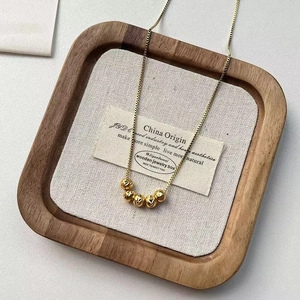 Detailansicht von fünf Goldperlen mit Herzgravuren an einer feinen Gliederkette