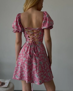 Détail d'une robe fleurie rose montrant le laçage au dos et les manches bouffantes