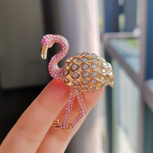 Detailed close-up of flamingo brooch featuring pink crystals and golden alloy base