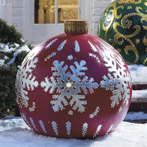Detail of red 60cm inflatable Christmas ball with silver snowflake patterns in snow
