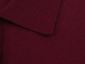 Gros plan sur la maille tricotée rouge foncé révélant la texture douce et les finitions
