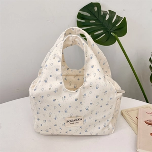 Detail of floral canvas lunch bag with blue flower pattern and handle stitching