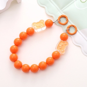 Detail of orange resin bead phone charm with cute bear charms and dual metal rings