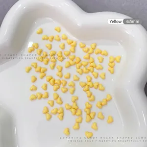 Detailed macro shot of yellow heart resin nail charms sized 4x5mm on a tray