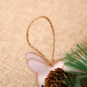 Detail of jute rope loop with pine cone and needles on rustic squirrel ornament