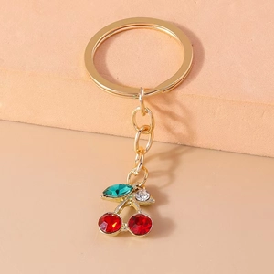Portachiavi con ciliegie di strass rossi scintillanti, finitura dorata e foglie verdi