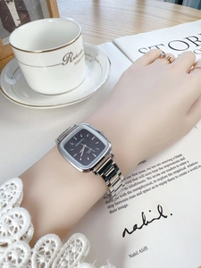 Elegant square silver metal quartz watch on wrist with deep blue dial and bar markers