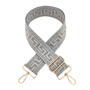 Close-up of adjustable bag strap with Greek Key pattern and gold-tone metal clasps
