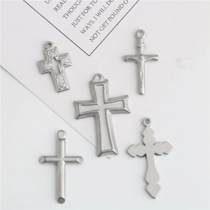 Set of five silver stainless steel cross pendants for DIY jewelry making on white background