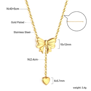 Detail of gold bow necklace with heart pendant and lobster clasp on white background