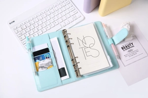 Close-up of light blue PU leather binder notebook with magnetic buckle and card slots