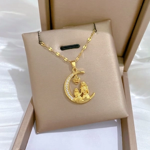 Gold moon heart necklace with sparkling crystals on a silk gift cushion display