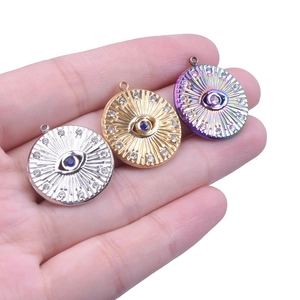 Detailed comparison of gold, silver, and rainbow eye pendants with blue gems in hand