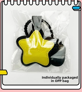 Close-up of yellow star leather keychain with black stitching in OPP bag packaging
