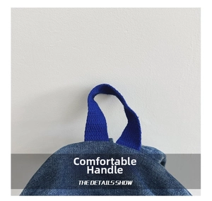 Detail showing durable reinforced blue denim carry handle with heavy-duty cross stitching