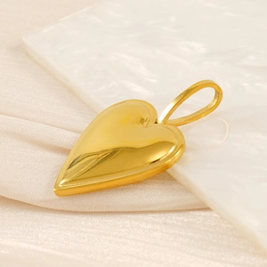Detailed close-up of golden heart pendant on white texture and silk fabric