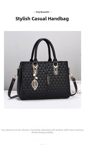Close-up of black handbag featuring geometric triangle embossed texture and gold leaf charm