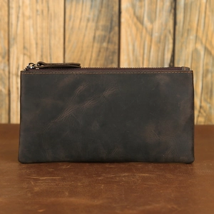 Close-up of vintage dark brown crazy horse leather wallet on rustic wooden background