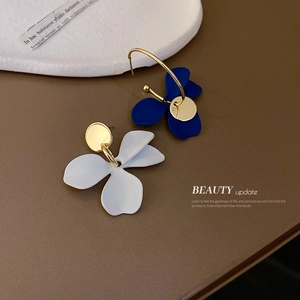 Boucles d'oreilles fleurs asymétriques avec pétales mats blanc et bleu et détails dorés