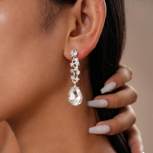 Close-up of elegant silver drop earrings with shimmering crystals and pear-shaped stones