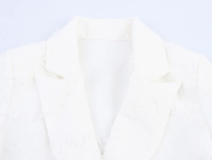 Dettaglio del colletto di un blazer bianco con frange e tessuto in tweed di alta qualità