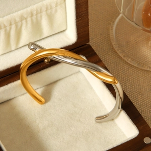 Detail view of two-tone gold and silver knotted stainless steel bracelet in jewelry box