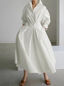 Détail de la robe chemise blanche à manches longues avec taille haute et jupe plissée