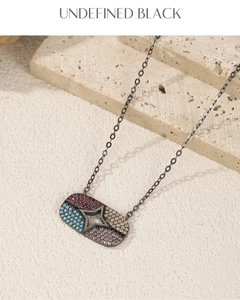 Gros plan d'un pendentif noir rectangulaire avec pierres colorées et étoile ajourée