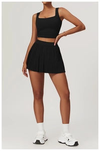 Detail of square neck fitted sports vest and high-waist pleated athletic skirt in black