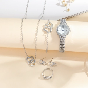 Macro detail of silver heart jewelry set featuring sparkling rhinestones and quartz watch
