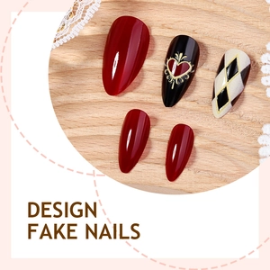 Faux ongles amande rouge foncé et monochromes avec motifs de cœur sur plateau bois