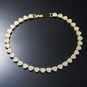 Golden heart-shaped Cuban link necklace with sparkling crystals on black background