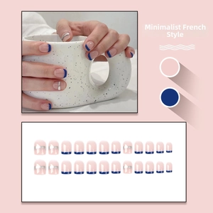 Detail of French press-on nails in nude pink and dark blue with silver accents