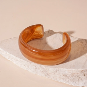 Detailed macro view of amber marble texture on this irregular acrylic open cuff bracelet