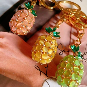 Macro shot of pineapple keychains with opal beads and crystal leaves in three vibrant colors