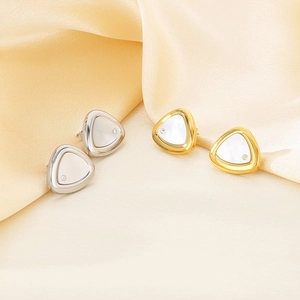 Elegant gold and silver triangle shell earrings with diamond studs on silk background