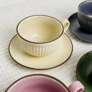 Detail of matte ceramic coffee cups with vertical relief texture and brown rims