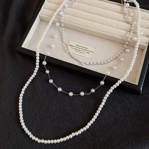 Close-up of elegant French vintage layered pearl necklace with silver chains on jewelry tray